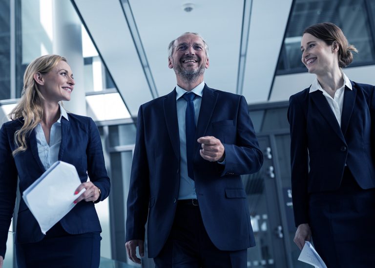 Management Beratung (Vorteile) 1920x896px Version 2 Bild zeigt Mitarbeiter, die auf dem Weg zu einer Besprechung sind.